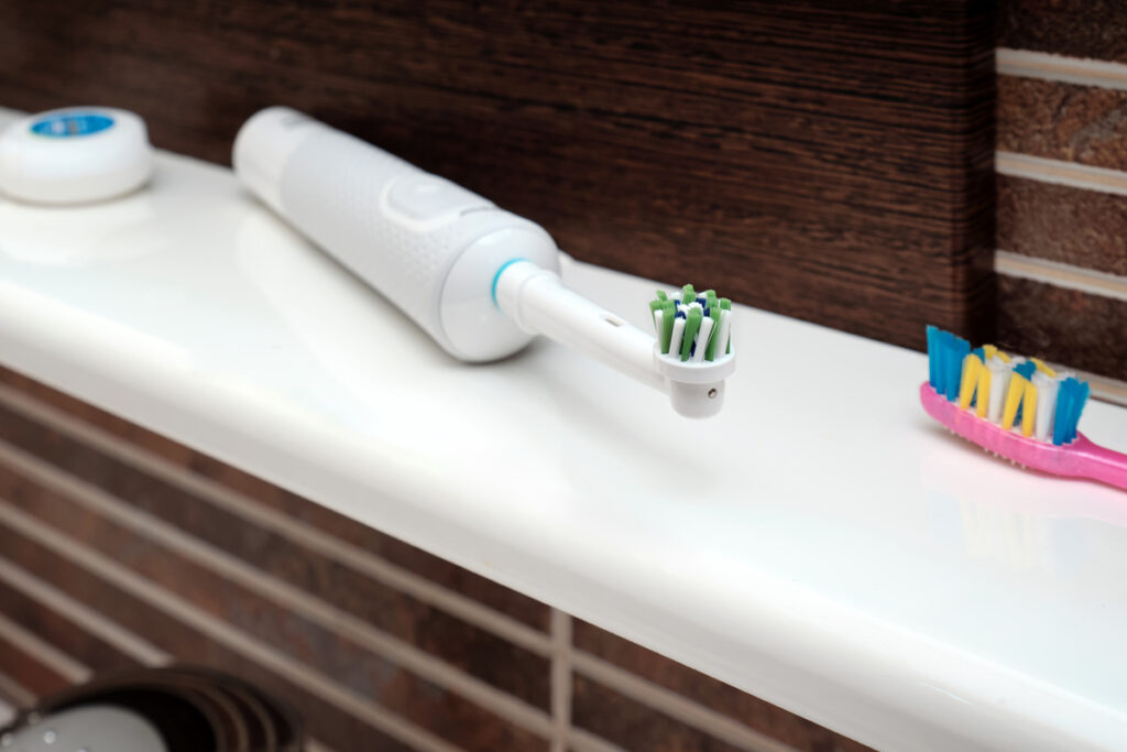Close a electric toothbrush and manual toothbrush on the bathroom sink. Which one to choose. Modern technologies for oral hygiene. Selective focus.