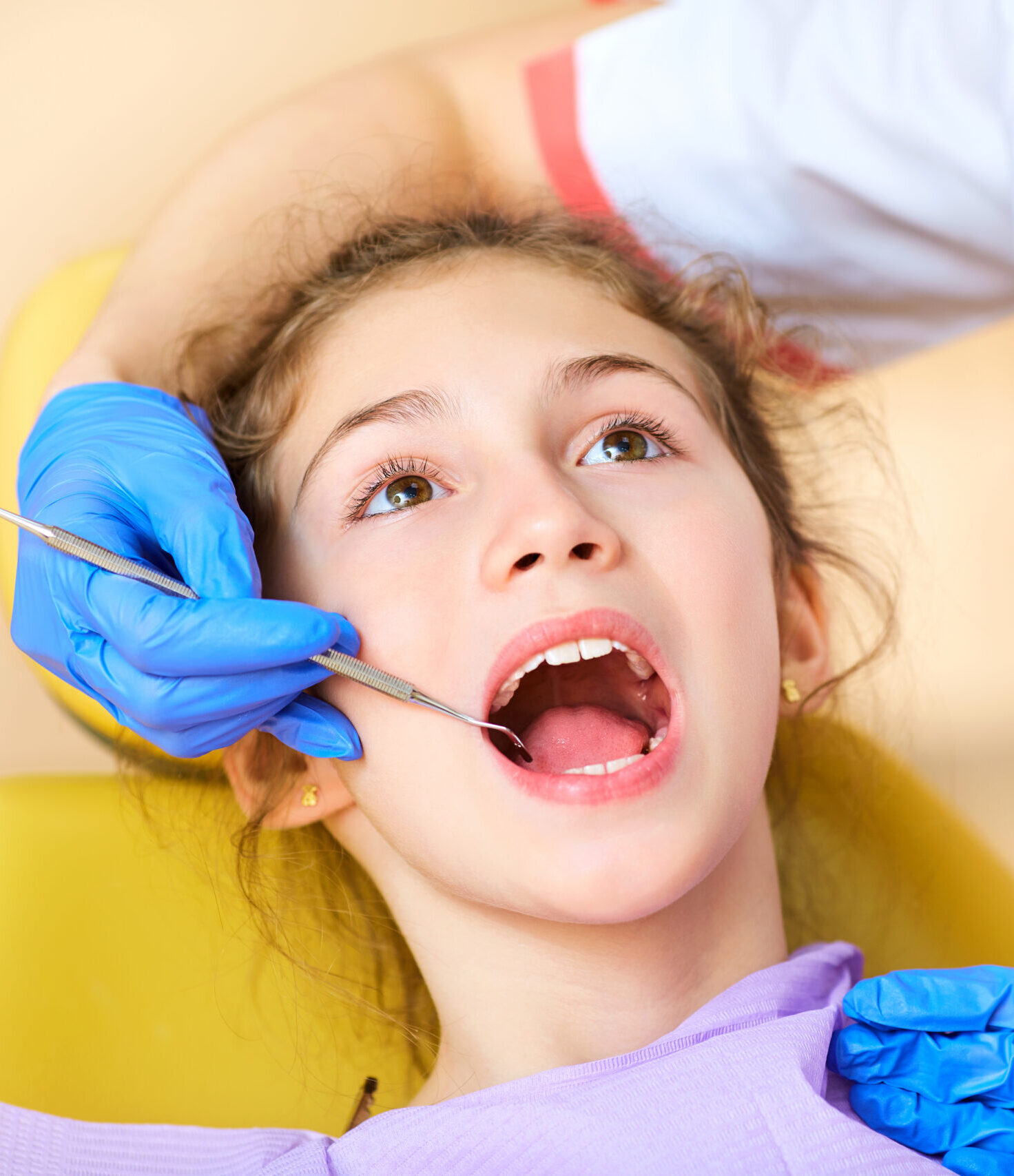Woman dentist treats your child's teeth in the dental office.