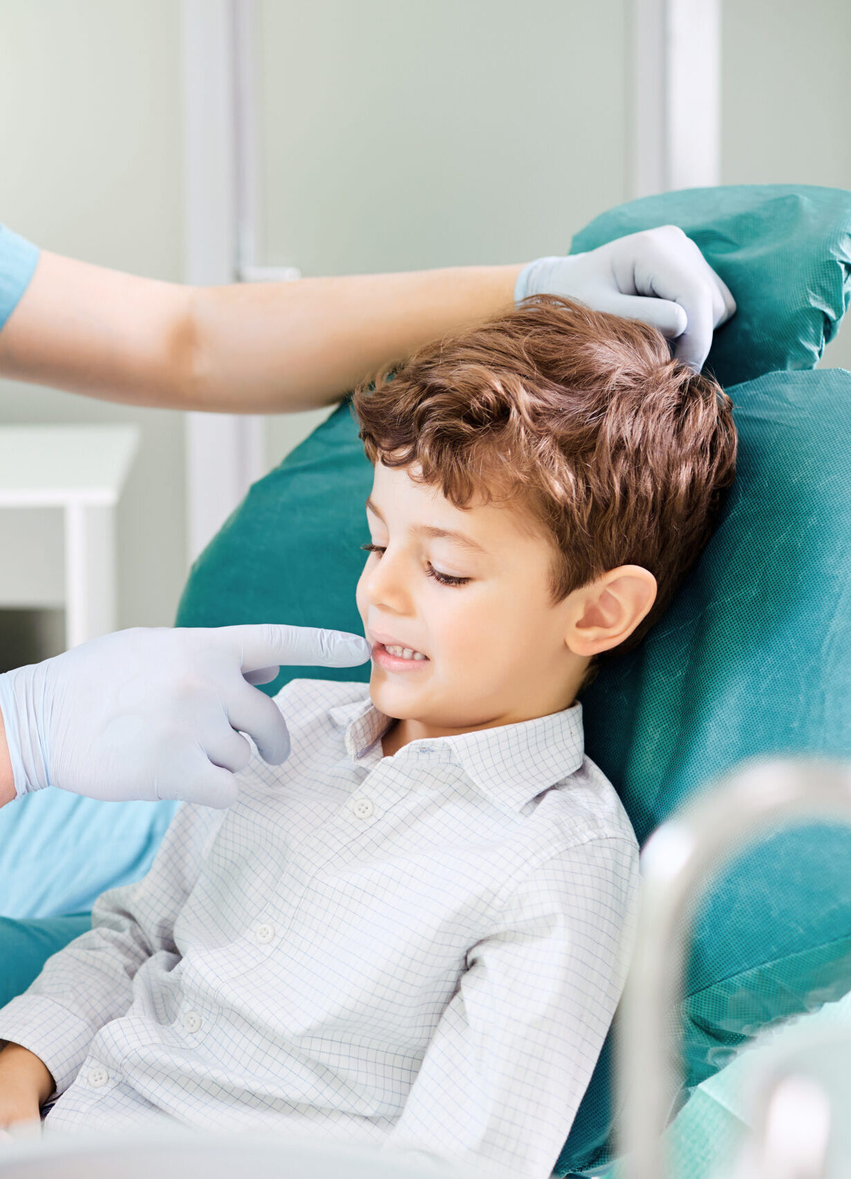 Boy child and dentist are checking teeth in the mirror in the dental clinic.