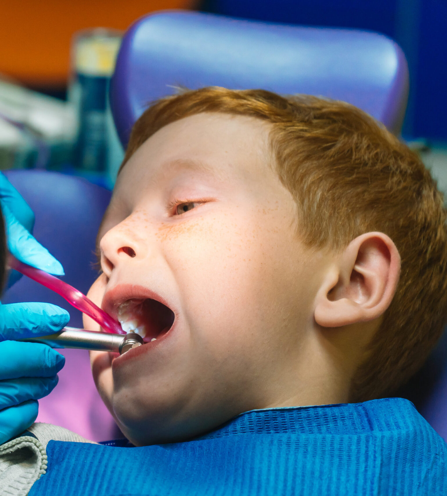 Scared red-haired boy crying at reception at dentist in dental chair