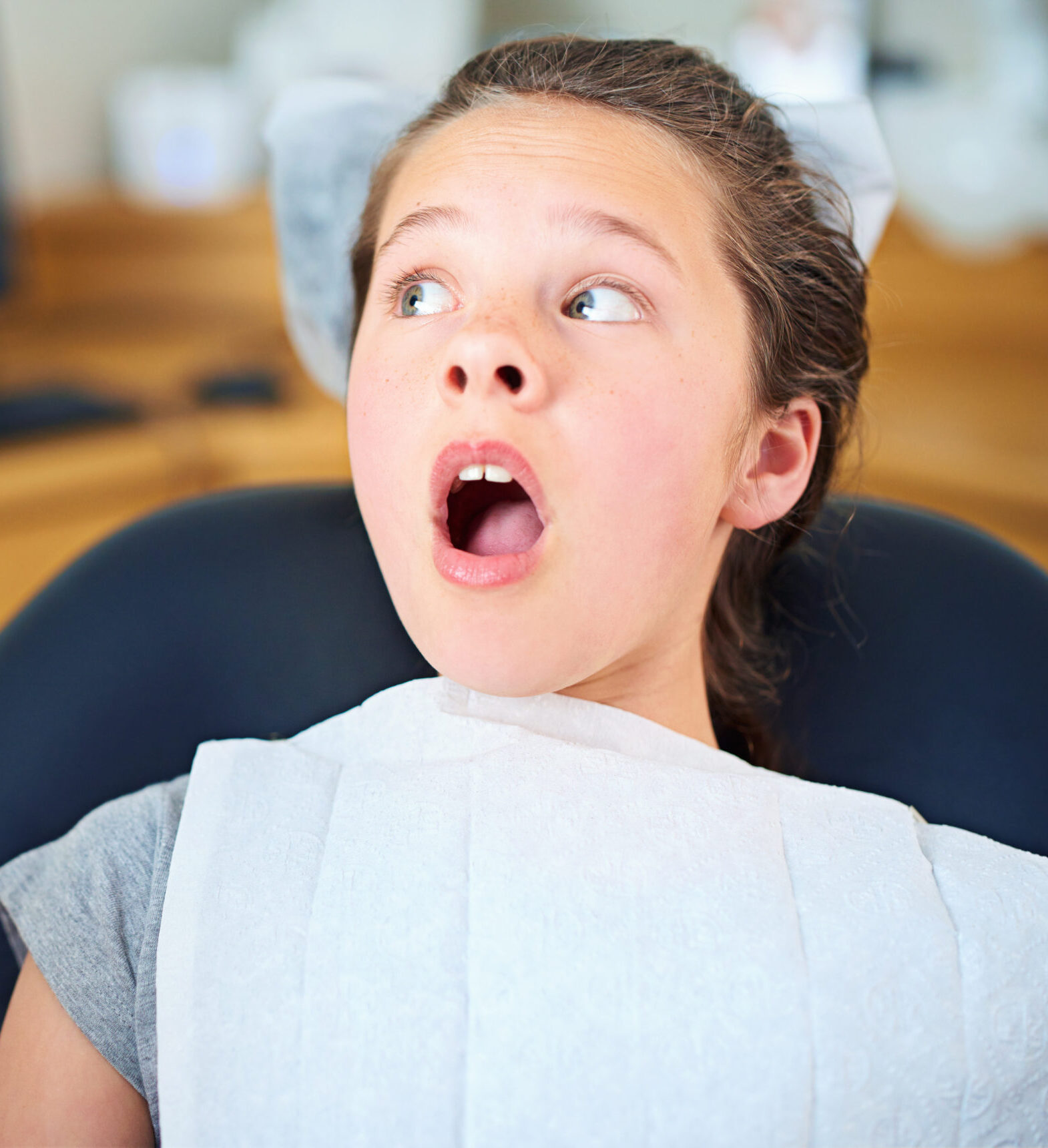 Dental, wow or scared girl in consultation room with phobia, worry or fear for dentist exam. Orthodontics, stress or teen person nervous for teeth, cavity or bacteria, risk or gum disease emergency.